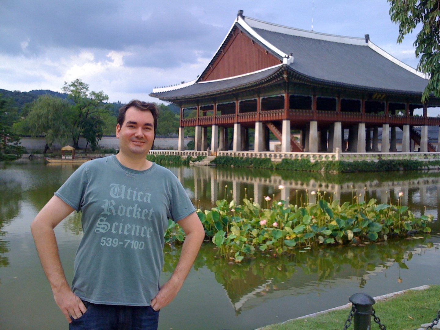 Raymond in front of Gyeonghoeru Pavilion at Gyeongbokgung Palace in Seoul, with a lotus pond and reflection.